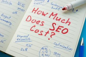 A notebook with "How Much Does SEO Cost?" writing, with notes on keyword research, optimisation, and other local SEO topics.