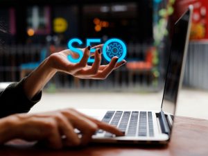 Close-up of hands typing on a laptop with “SEO” graphic, symbolising SEO plans for small businesses.