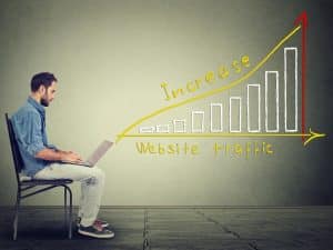 Man using laptop with graph showing growth in website traffic, symbolising success with monthly SEO packages.