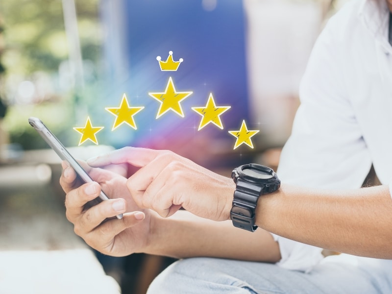 Person tapping phone with star ratings linked to seo marketing package success