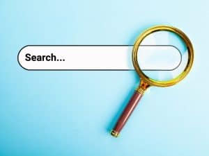 Magnifying glass over a search bar on blue background, representing search intent targeted by AEO strategies