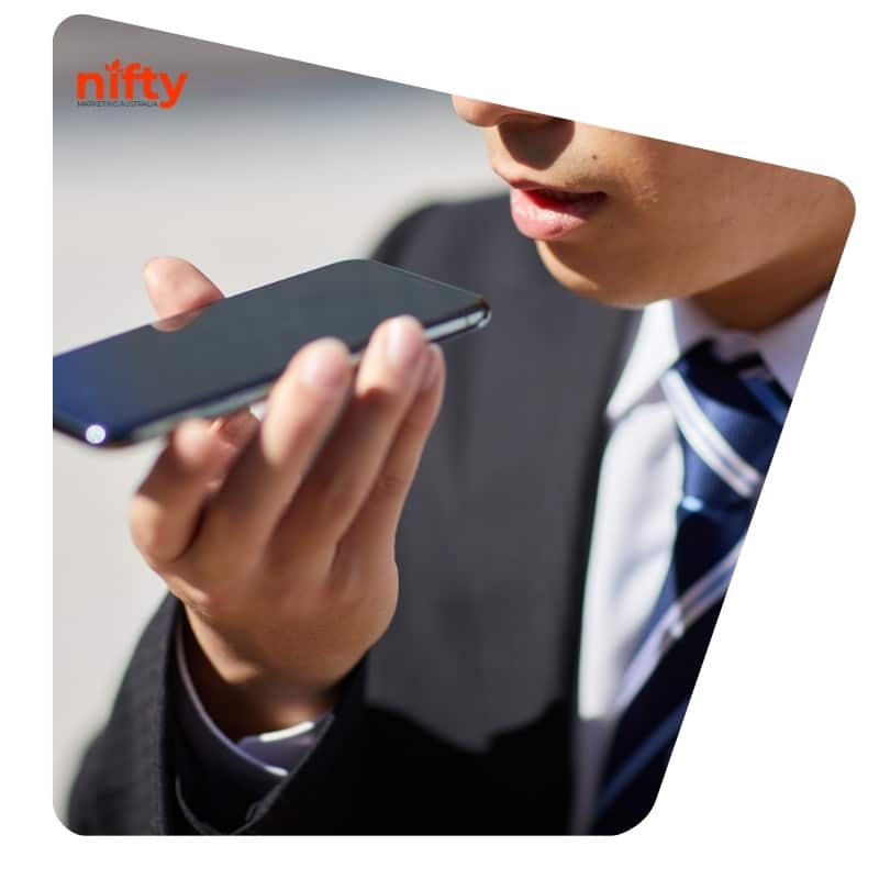 Businessman using voice search on smartphone, demonstrating AEO strategies for enhanced voice-driven search engine visibility.