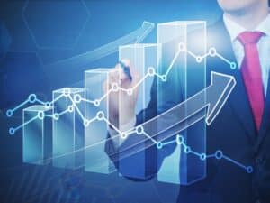 Business professional drawing an upward arrow on a graph representing growth in digital marketing advertising performance.