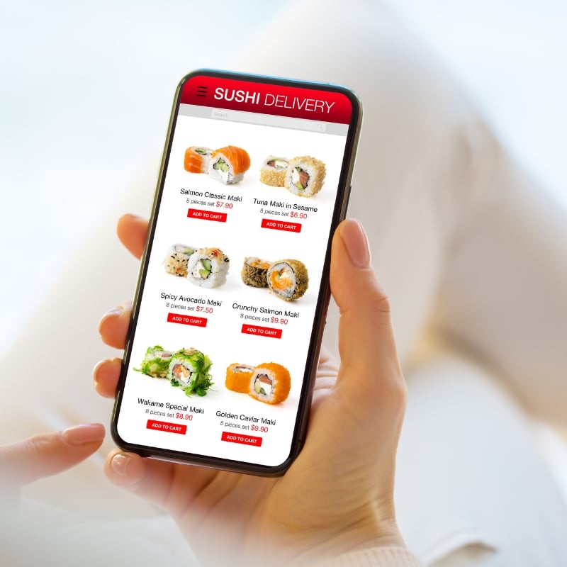Team analysing performance graphs on a desktop screen in an office environment, discussing Mobile SEO data and improvements.