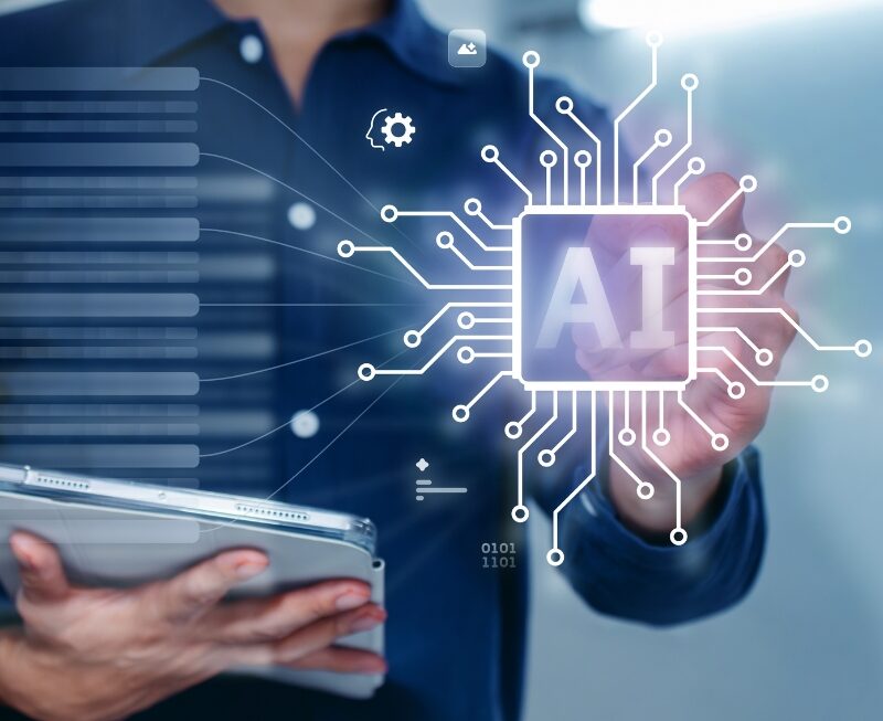 professional holding a tablet while interacting with a glowing AI chip graphic representing data processes and AEO systems.